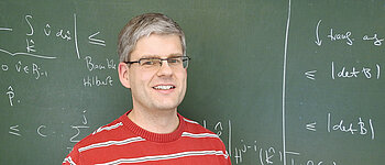 Professor Daniel Wachsmuth in front of a blackboard